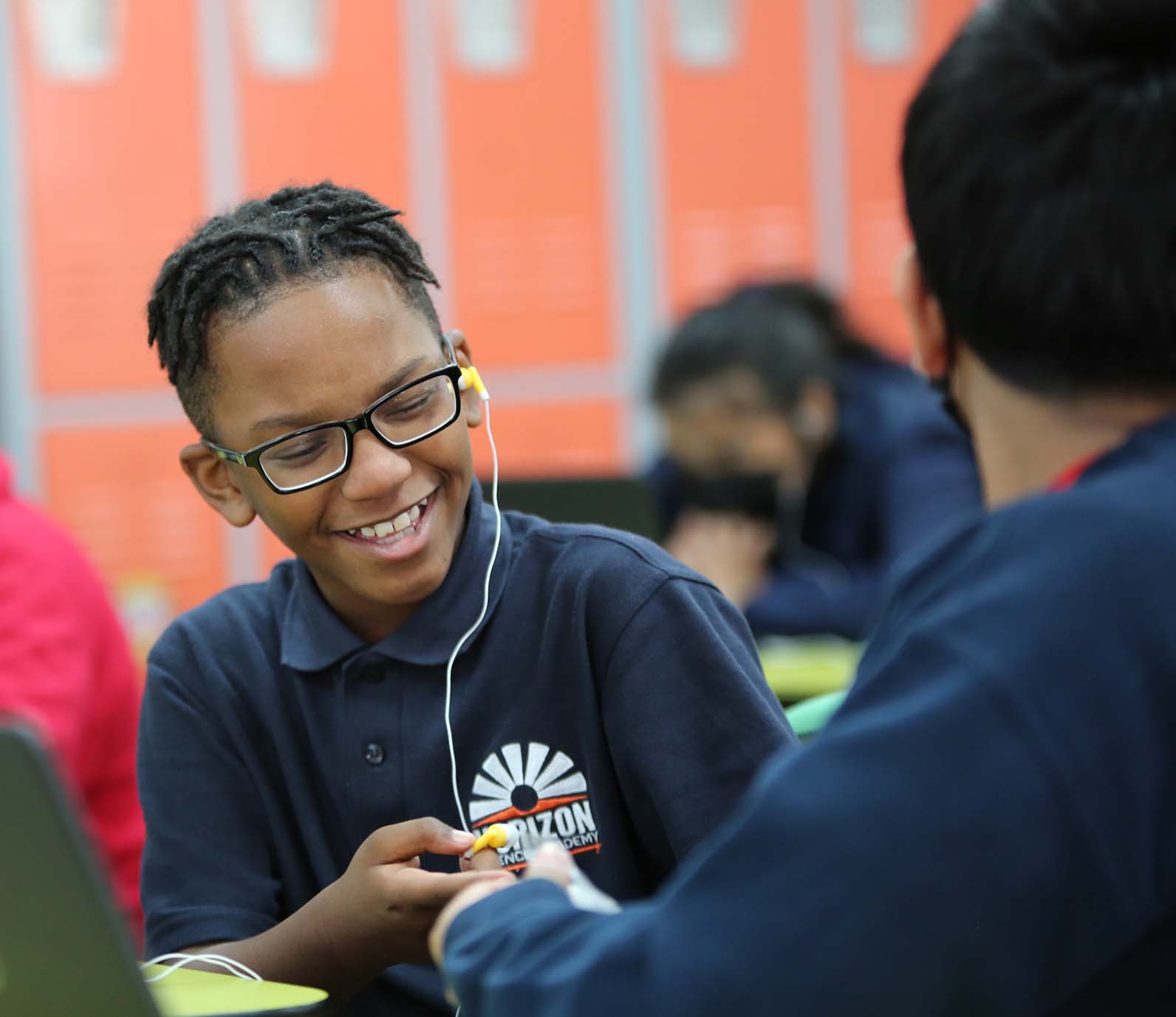 Horizon Science Academy Belmont student wearing headphones uses a laptop in class