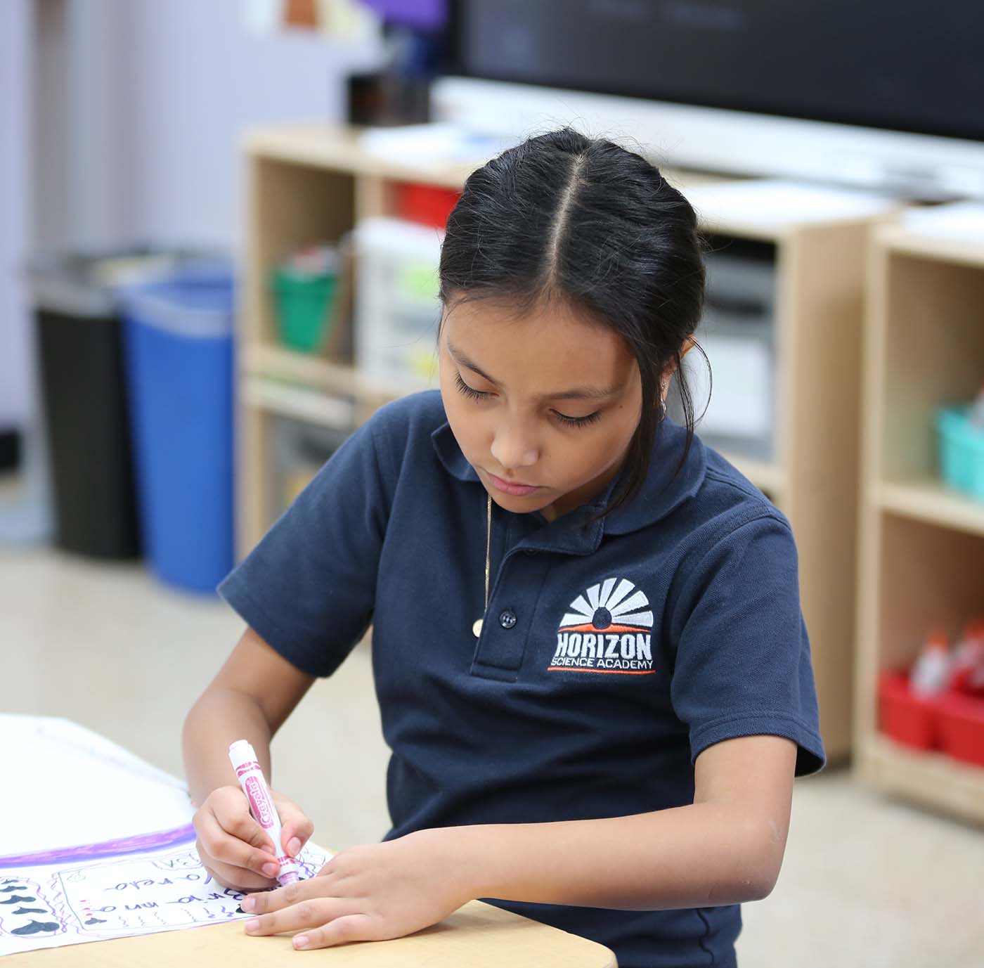 Horizon Science Academy Belmont student drawing at a desk in a classroom setting