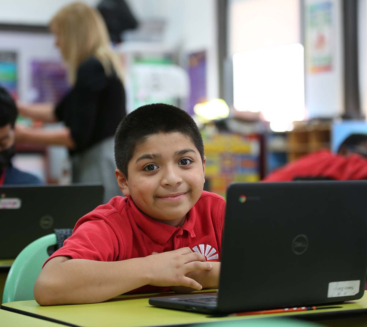 Student working on a notebook in a classroom.